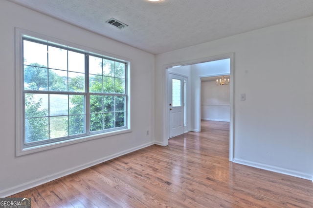 2869 Hickory Run Cir, Duluth, GA 30096 - unfurnished room featuring visible vents, baseboards, wood finished floors, and a chandelier