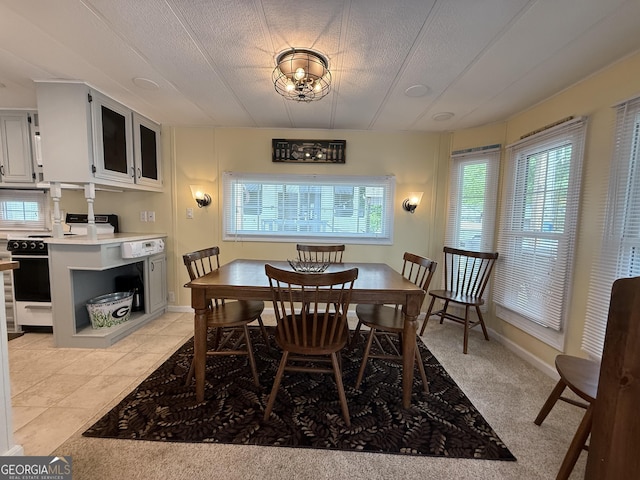 dining space featuring plenty of natural light, a textured ceiling, and baseboards