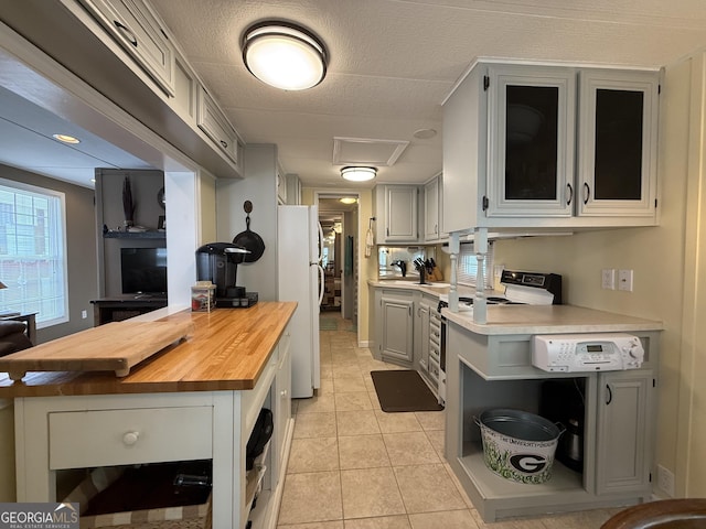kitchen featuring open shelves, electric range, butcher block countertops, and freestanding refrigerator