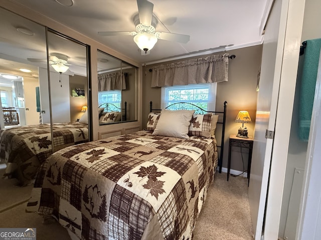bedroom with carpet flooring, multiple closets, and a ceiling fan