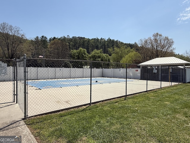 view of swimming pool featuring a lawn and fence