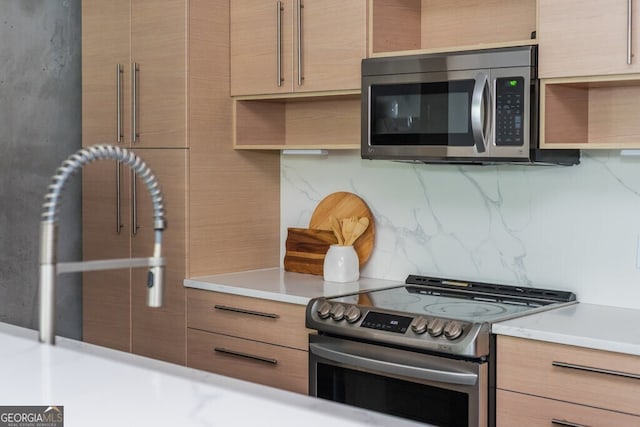 kitchen with light countertops, appliances with stainless steel finishes, tasteful backsplash, and open shelves