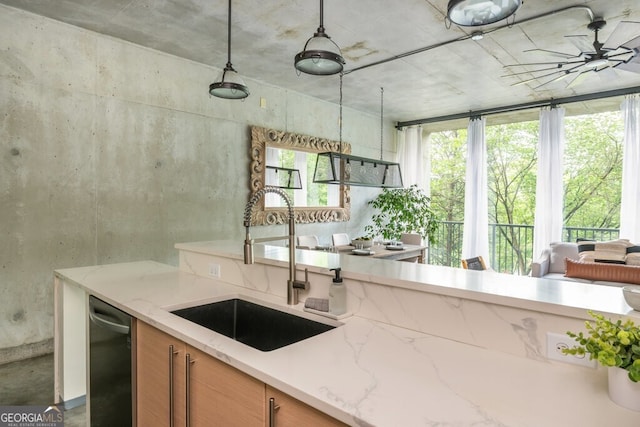 kitchen with ceiling fan, light stone countertops, brown cabinets, dishwasher, and a sink