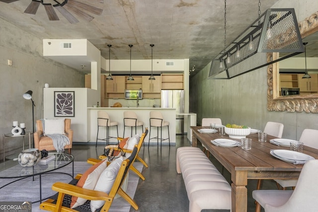dining area with a ceiling fan, finished concrete floors, and visible vents