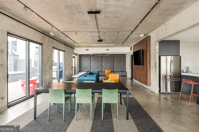 dining room with rail lighting, visible vents, and concrete floors