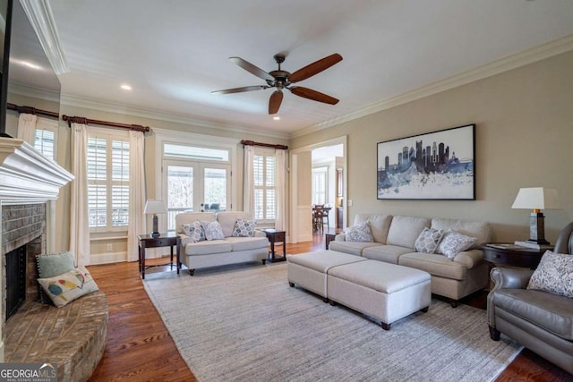 431 Tralee Ct, Statham, GA 30666 - living room featuring a ceiling fan, wood finished floors, healthy amount of natural light, a fireplace, and crown molding