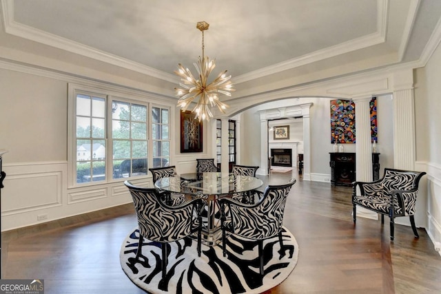 1898 Sam Snead Dr, Braselton, GA 30517 - dining room with dark wood-style flooring, arched walkways, an inviting chandelier, ornate columns, and a premium fireplace