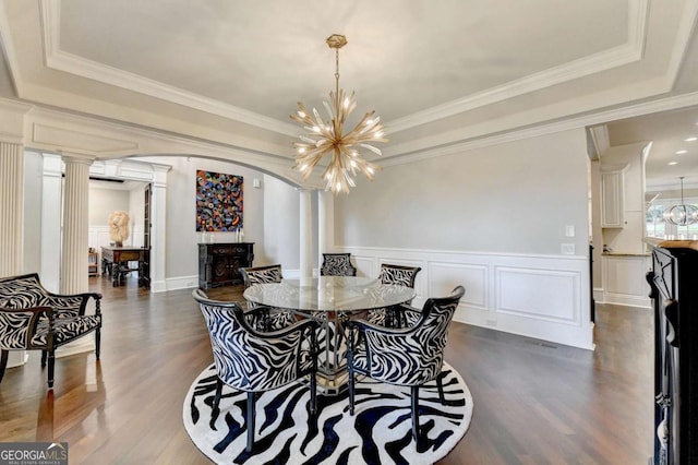 1898 Sam Snead Dr, Braselton, GA 30517 - dining room with ornate columns, a tray ceiling, dark wood finished floors, and arched walkways