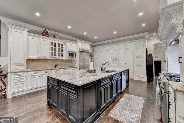 1898 Sam Snead Dr, Braselton, GA 30517 - kitchen featuring a sink, built in appliances, white cabinets, and ornamental molding