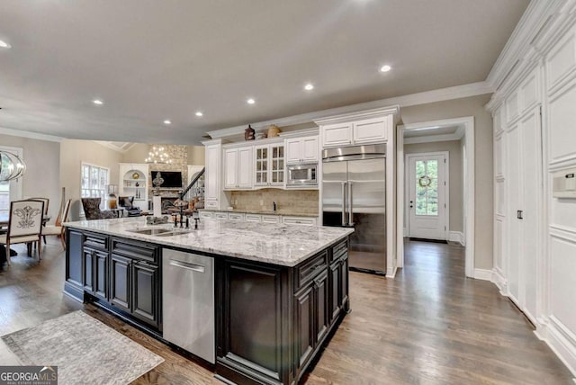 1898 Sam Snead Dr, Braselton, GA 30517 - kitchen featuring white cabinets, a sink, built in appliances, tasteful backsplash, and a spacious island
