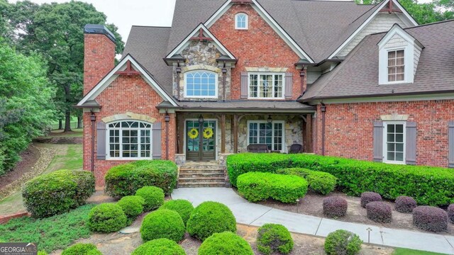 1898 Sam Snead Dr, Braselton, GA 30517 - view of front of property with brick siding, roof with shingles, french doors, and a chimney