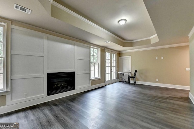 1898 Sam Snead Dr, Braselton, GA 30517 - unfurnished living room featuring a raised ceiling, dark wood finished floors, a glass covered fireplace, visible vents, and ornamental molding