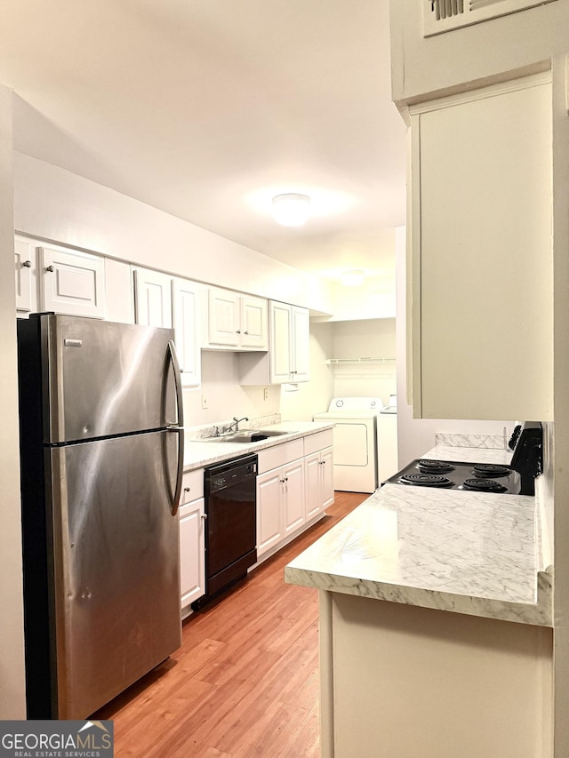 kitchen with freestanding refrigerator, range with electric stovetop, a sink, independent washer and dryer, and dishwasher