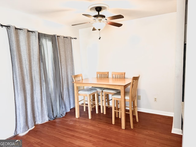 dining room with baseboards, ceiling fan, and wood finished floors