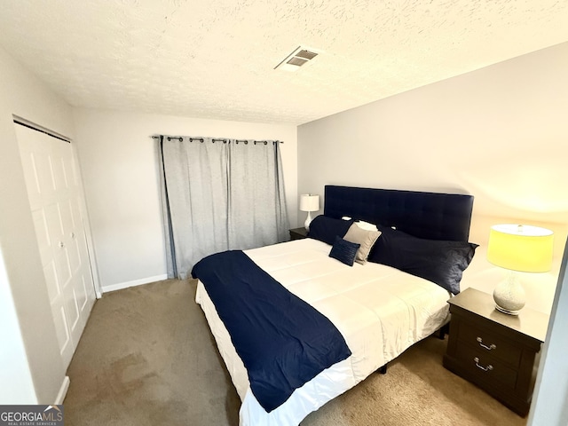 bedroom featuring baseboards, carpet flooring, a textured ceiling, and visible vents