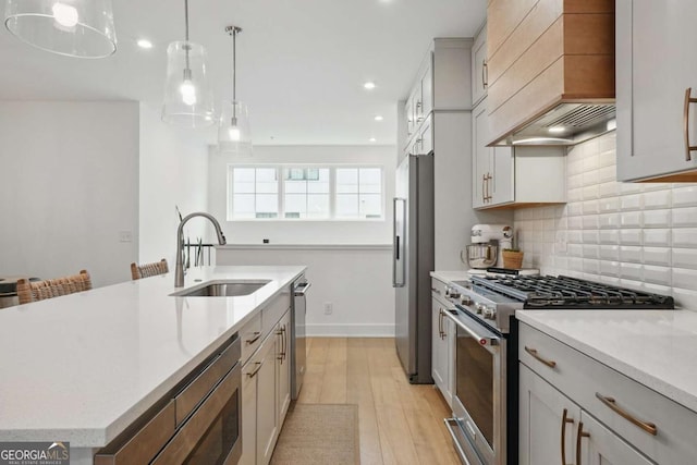 230 New St Unit 2102, Decatur, GA 30030 - kitchen featuring stainless steel appliances, custom exhaust hood, light wood-style flooring, backsplash, and a center island with sink