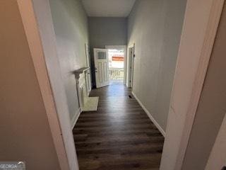 corridor with baseboards and wood finished floors