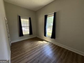 empty room with baseboards and wood finished floors