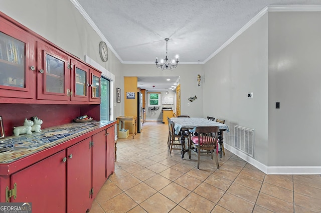 100 Tanglewood Rd, Eatonton, GA 31024 - dining area featuring a textured ceiling, visible vents, crown molding, light tile patterned floors, and an inviting chandelier