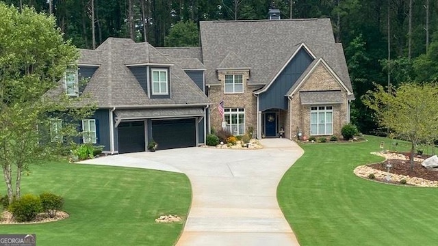 view of front of home featuring a wooded view, a shingled roof, concrete driveway, and a front yard