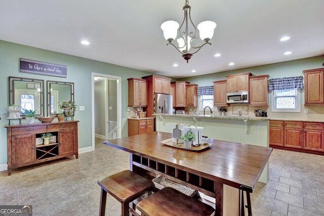 kitchen with appliances with stainless steel finishes, decorative backsplash, recessed lighting, and light stone counters