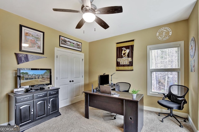office area with baseboards, ceiling fan, and light carpet