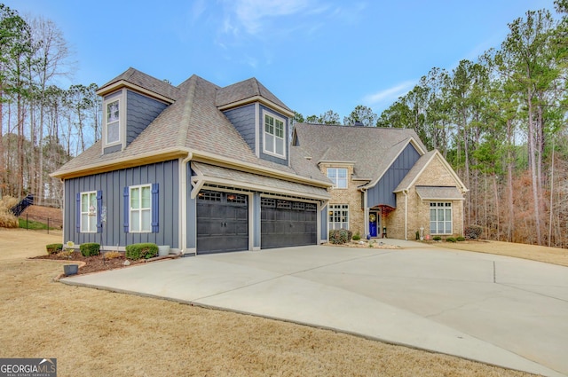 view of front of house featuring a shingled roof, board and batten siding, driveway, and a garage