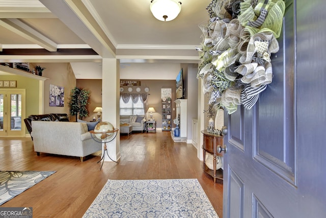 foyer featuring crown molding, baseboards, and wood finished floors