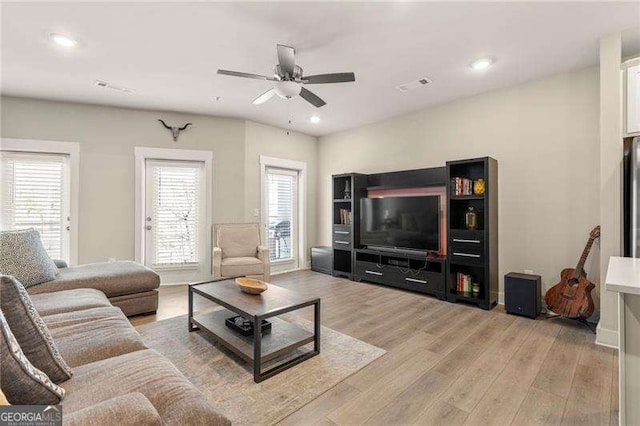 living room featuring a ceiling fan, visible vents, recessed lighting, and light wood-style floors