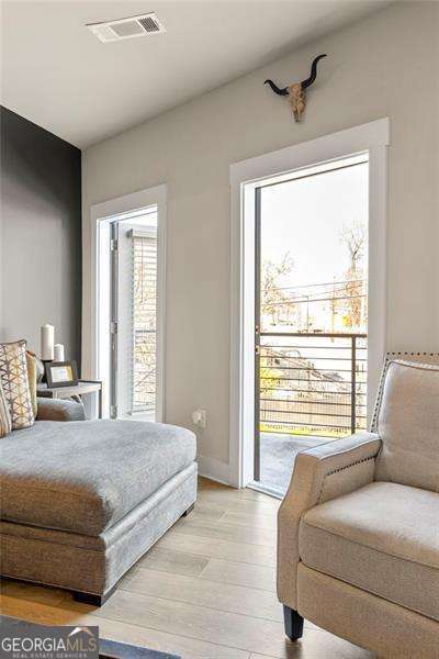 bedroom featuring baseboards, access to exterior, light wood-type flooring, and visible vents