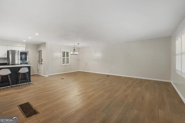 3813 Wingate Dr, Columbus, GA 31909 - unfurnished living room with baseboards, visible vents, plenty of natural light, and an inviting chandelier