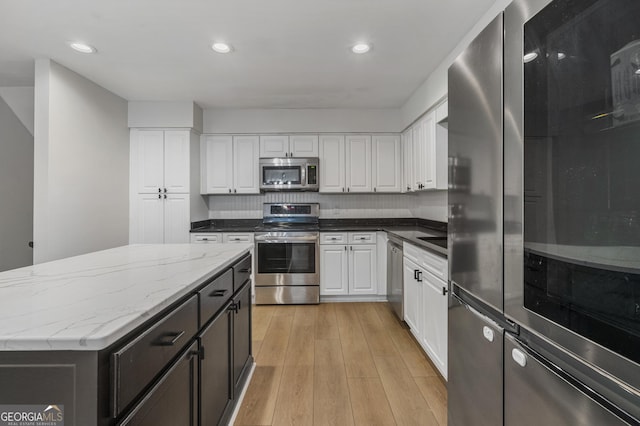 3813 Wingate Dr, Columbus, GA 31909 - kitchen featuring white cabinetry, appliances with stainless steel finishes, light wood-style flooring, and light stone counters