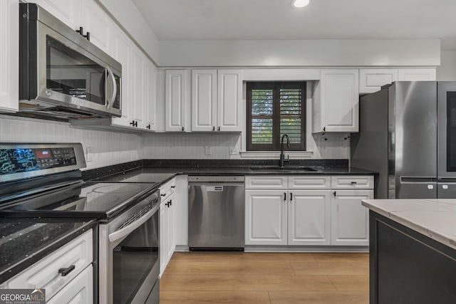 3813 Wingate Dr, Columbus, GA 31909 - kitchen featuring a sink, appliances with stainless steel finishes, white cabinets, and dark stone countertops