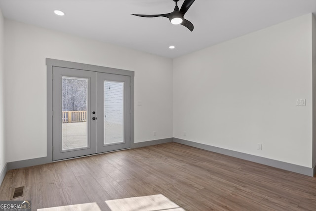 empty room featuring visible vents, baseboards, ceiling fan, and wood finished floors