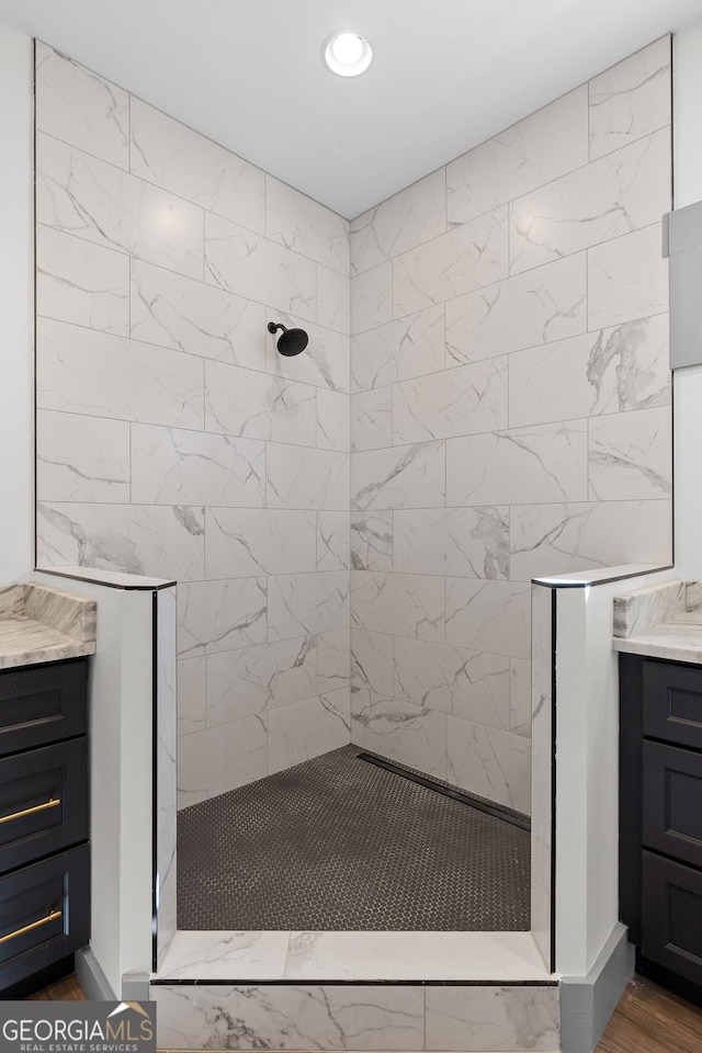 bathroom featuring vanity, a fireplace, walk in shower, and recessed lighting