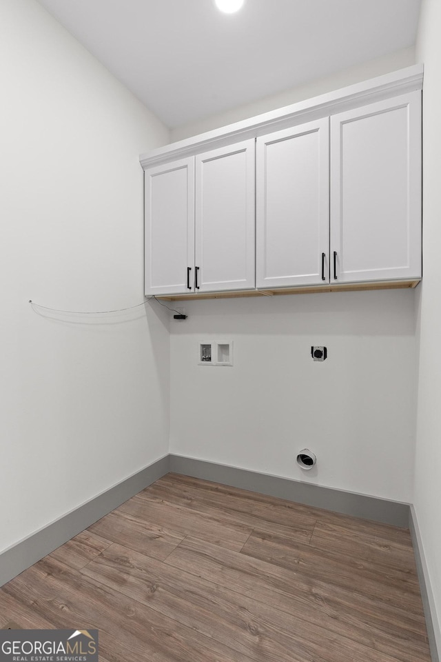 laundry room with cabinet space, washer hookup, electric dryer hookup, baseboards, and wood finished floors