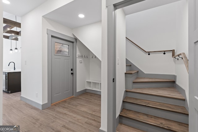 stairway with recessed lighting, baseboards, and wood finished floors