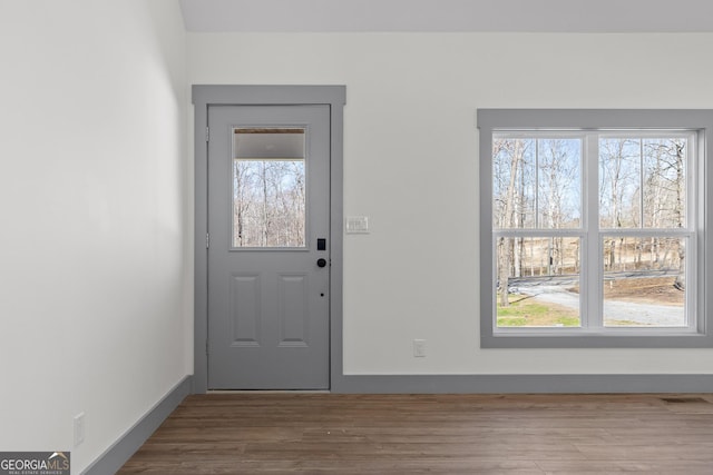 foyer featuring wood finished floors and visible vents