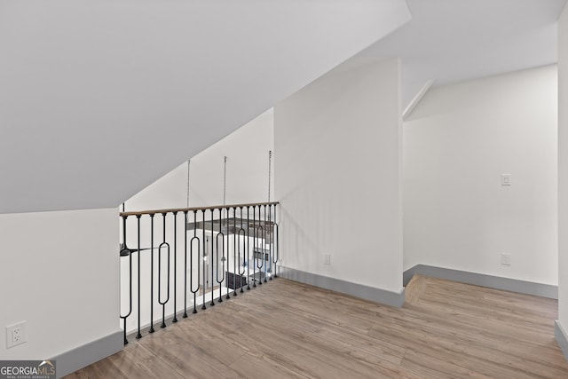 bonus room featuring baseboards and wood finished floors