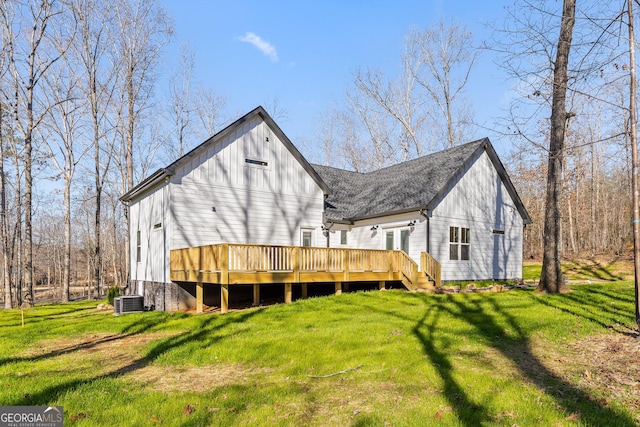 rear view of house featuring french doors, roof with shingles, a deck, cooling unit, and a yard