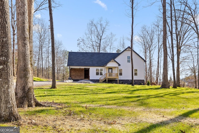 view of front of house with a shingled roof and a front yard