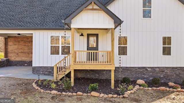 view of exterior entry featuring roof with shingles and board and batten siding