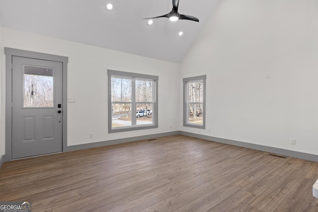 foyer entrance featuring baseboards, a ceiling fan, high vaulted ceiling, and wood finished floors