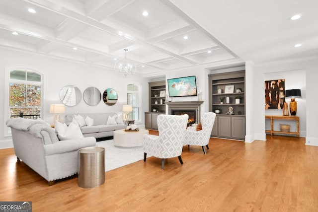 living area with light wood-type flooring, built in shelves, a warm lit fireplace, a chandelier, and recessed lighting