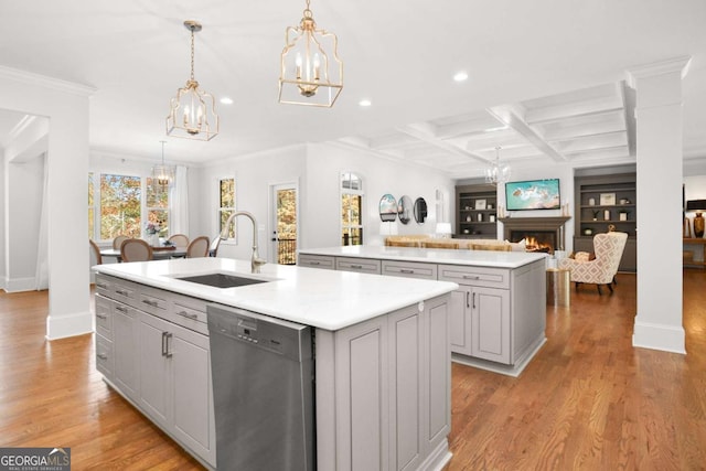 kitchen featuring a notable chandelier, a sink, a kitchen island with sink, gray cabinets, and stainless steel dishwasher