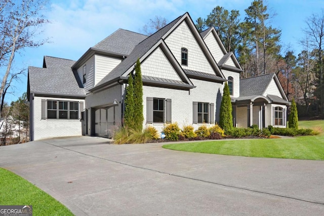 craftsman-style house featuring brick siding, a shingled roof, a front lawn, and concrete driveway