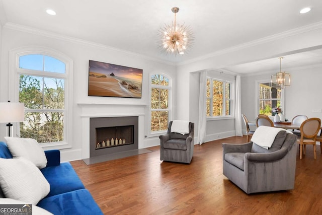 living area featuring a notable chandelier, a healthy amount of sunlight, and wood finished floors
