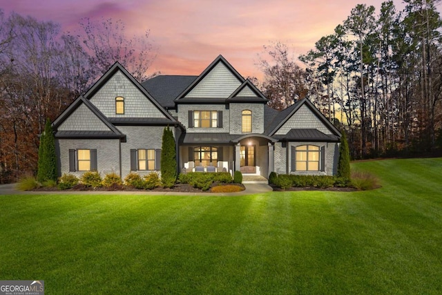 craftsman inspired home with a standing seam roof, a yard, and metal roof