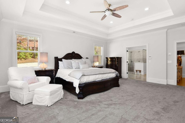 carpeted bedroom featuring crown molding, a raised ceiling, baseboards, and multiple windows
