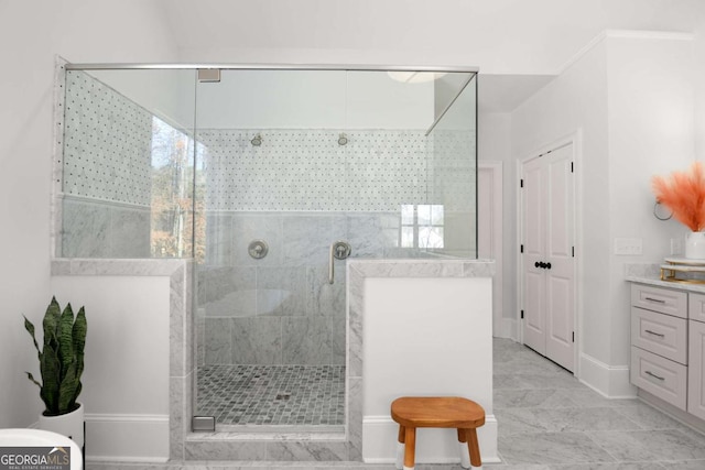 bathroom featuring vanity, baseboards, and a stall shower